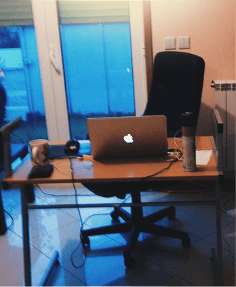 A desk with a single laptop in an apartment setting